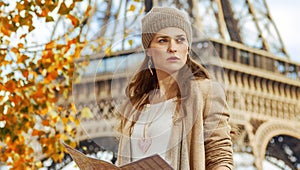 Woman on embankment in Paris with map looking into the distance