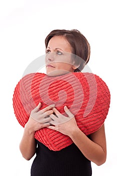 Woman embrace a heart-shape pillow