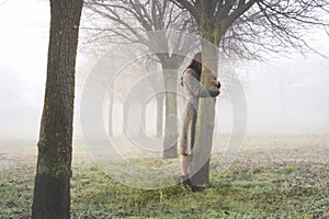 woman embraces with love the trunk of a tree symbol of life, abstract concept