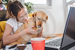 Woman embracing dog sitting on floor