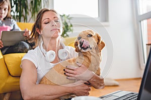 Woman embracing dog sitting on floor