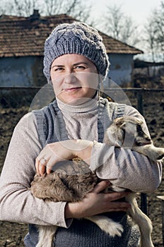 Woman embracing a goatling.