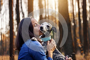 Woman embracing her dog and giving kiss to him