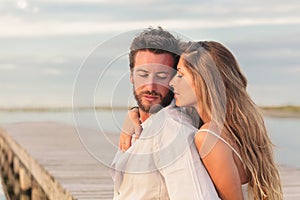 Woman embracing her man from behind at seaside