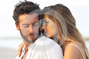 Woman embracing her man from behind on seaside background