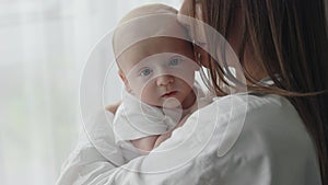 Woman embracing and kissing her newborn son at home