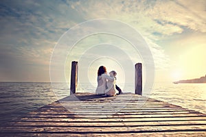 Woman embracing sweetly his dog while looking the view