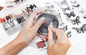 Woman embroider a butterfly. Process of making handmade embroidery. Hobby. Sewing tools. Remote home work.