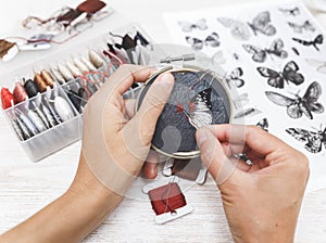 Woman embroider a butterfly. Process of making handmade embroidery. Hobby. Sewing tools. Remote home work.