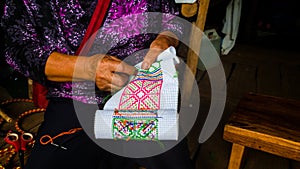 Woman embroidering traditional handicraft fabric for homemade clothes. photo
