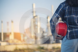 Woman Emergency workers hands holding hardhat red work helmet Engineer. Refinery plant woman worker oil petrochemical industry