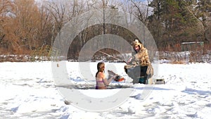 Woman emerges from cold water in winter.