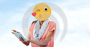 Woman with emoji over face using tablet PC