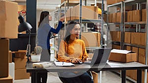 Woman employee analyzing products from racks