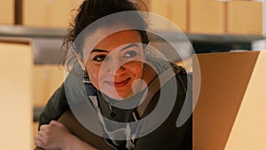 Woman employee moving boxes on shelves