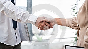 Woman employer is shaking hands to congratulate with the new employee after successful with job interview