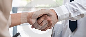 Woman employer is shaking hands to congratulate with the new employee after successful with job interview