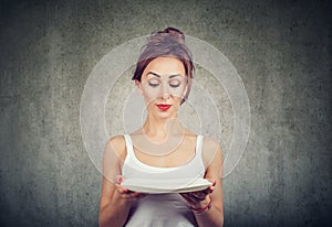 Woman with empty plate being on diet