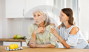 Woman encouraging her upset senior mother