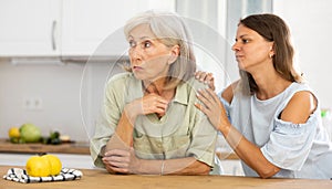 Woman encouraging her upset senior mother