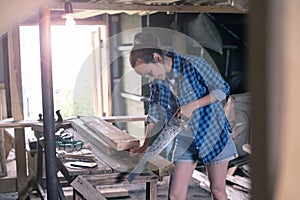 Woman engaged in processing wood in the home workshop, carpentry