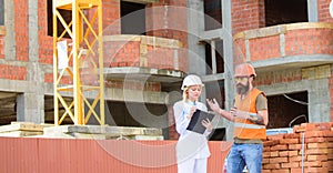 Woman engineer and builder communicate at construction site. Construction team communication concept. Relationships