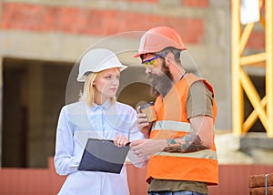 Woman engineer and builder communicate construction site. Discuss progress plan. Relationships between construction