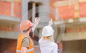 Woman engineer and builder communicate construction site. Relationships between construction clients and participant