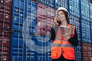 Woman Engineer, Using a communication radio and working in Shipment Industry, logistic Import-Export Cargo Terminal