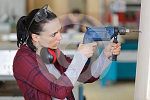 woman engineer using electric drilling machine