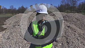 Woman engineer using laptop at the gravel pile