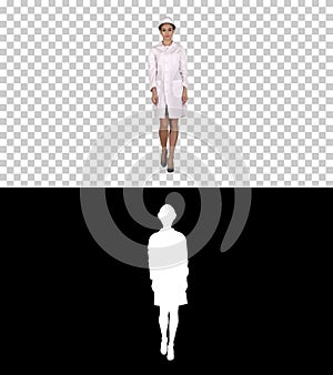 Woman engineer in white robe and white hard hat walking, Alpha C