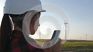 Woman engineer working in wind turbine electricity industrial at sunset.