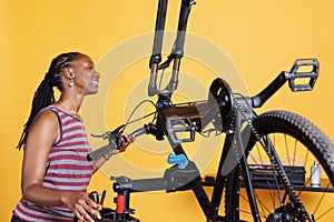 Woman engrossed in fixing bicycle parts