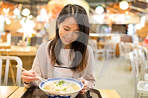 Woman enjoy her japanese ramen in restaurant