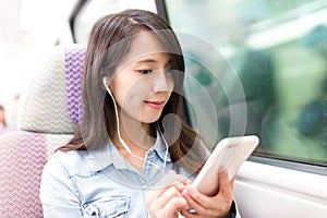 Woman enjoy music on cellphone inside train compartment