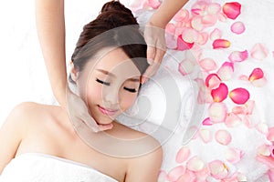 Woman enjoy receiving face massage at spa with roses