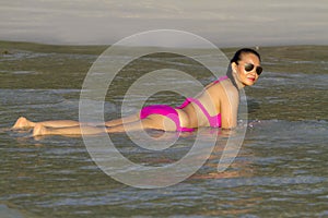 Woman enjoy watet on beach with pink bikini