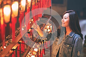 Woman enjoyed looking at red lamps and wishes in Chinese templeA beautiful asian woman enjoyed looking at red