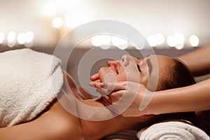 Woman enjoying anti aging facial massage, side view