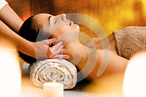 Woman enjoying aromatic oil massage at candlelight.