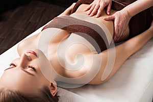 Woman enjoying Ayurveda oil massage in spa