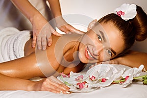 Woman enjoying back massage, smiling at camera