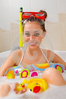 Woman is enjoying a bath in mask with snorkel.