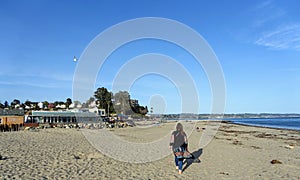 A woman enjoying a beautiful evening with views of Monterey Bay, along the beachfront of Capitola, California, United States