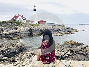 Woman enjoying beautiful view of Portland lighthouse in Portland Maine USA