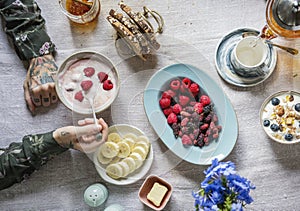 Woman enjoying berries and yogurt for breakfast