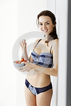 Woman enjoying a bowl of strawberries