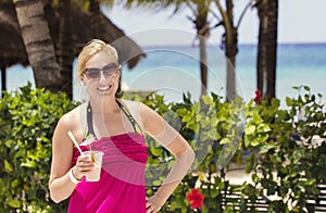 Woman enjoying a cocktail drink by the beach