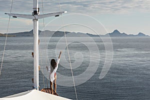 Woman enjoying cruise on luxury white yacht. Wealth and freedom travel concept